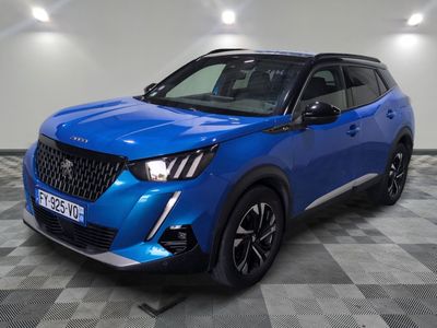 un 4x4 bleu garé sur un sol en damier dans un garage