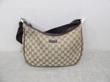 beige and black guccissi bag on a white surface