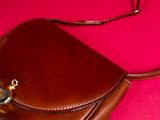 a brown purse on a pink surface with a red background