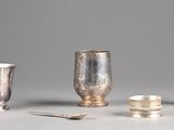 quatre tasses et cuillères en argent posées sur une table
