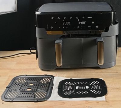 une friteuse à air chaud noire posée sur une table en bois