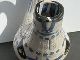 a blue and white vase sitting on a black table