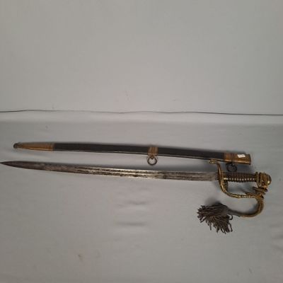 une épée avec une poignée en or et un pompon sur un fond blanc
