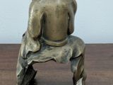 a small statue of a man sitting on a bench