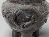 a large metal vase with a dragon design on it