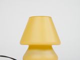 yellow table lamp with a black cord on a white surface
