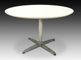 une image représentant une table blanche dotée d'un piètement en croix métallique