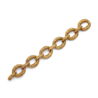 a gold bracelet with a twisted design on a white background