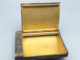a small metal box with a lid on a white surface