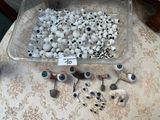 a lot of fake eyeballs in a plastic container on a table