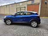 a blue car parked in a parking lot next to a building