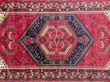 a red and blue rug with a diamond design on it