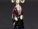 figurine représentant une femme avec un chapeau et un sac