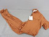 an orange jacket and pants laying on a bed with a tag on it