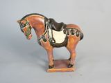 a figurine of a horse with a saddle on it ' s back