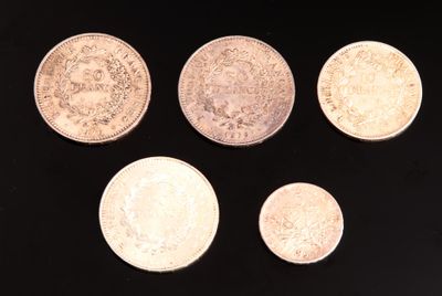 six types différents de pièces d'argent sur une surface noire