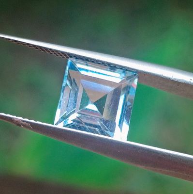 un diamant bleu tenu par une pince