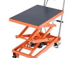 une paire de ciseaux orange posée sur un socle métallique