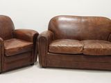une paire de canapés en cuir marron avec accoudoirs et repose-pieds assortis