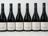 six bouteilles de vin sont alignées sur une surface blanche