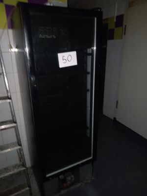 une photo d'un réfrigérateur dans une pièce, avec une affiche sur la porte