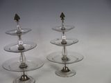 three tiered glass plates with silver decorations on them