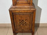 a grandfather clock sitting on top of a wooden cabinet