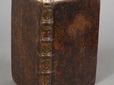 un vieux livre à la couverture brune posé sur une table