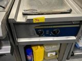 a stove with a pan on it in a commercial kitchen