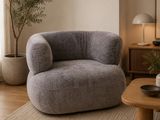 a grey chair in a living room with a coffee table