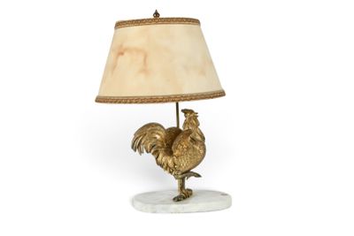une photo d'une lampe de table sur laquelle est posé un coq
