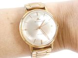 a gold wrist watch on a woman ' s wrist