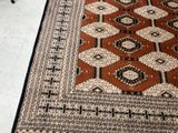 a rug on the floor with a chair in the background