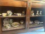 many cups and saucers sitting on a shelf
