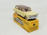 yellow toy car sitting on top of a box on a white surface