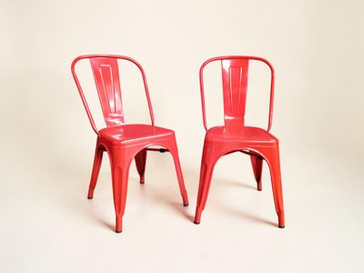 deux chaises rouges placées l'une à côté de l'autre sur une surface blanche
