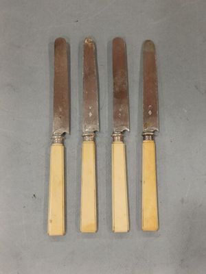 trois couteaux sont posés sur une table, les uns à côté des autres