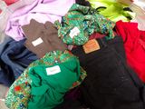 une pile de vêtements posée sur un lit