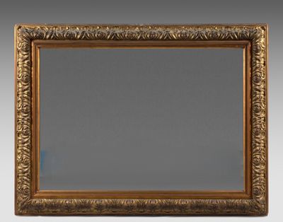 un miroir à cadre doré orné d'un motif décoratif sur fond gris