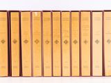a set of five books sitting on top of each other on a white surface
