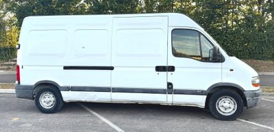 une camionnette blanche garée sur un parking avec des arbres en arrière-plan