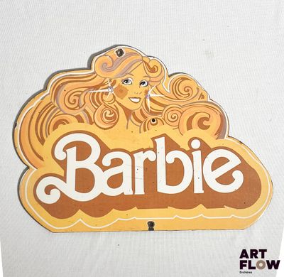 une photo d'une affiche Barbie accrochée à un mur