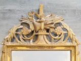 a mirror with a gold frame and a bird on it