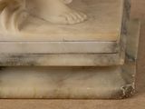 a statue of a woman sitting on top of a marble block