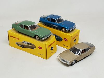 three toy cars are sitting in a box on a white surface