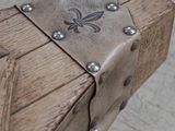 un banc en bois orné de clous métalliques, avec un skateboard en arrière-plan