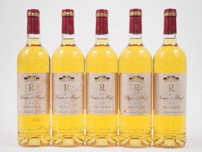 quatre bouteilles de vin posées les unes à côté des autres sur une surface blanche