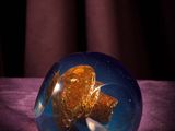 a glass ball with a teddy bear inside of it on a table