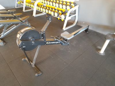 une rangée d'appareils d'exercice dans une salle de sport
