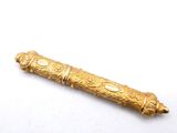 a gold object on a white surface with a white background